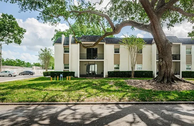 a front view of house with a garden and trees