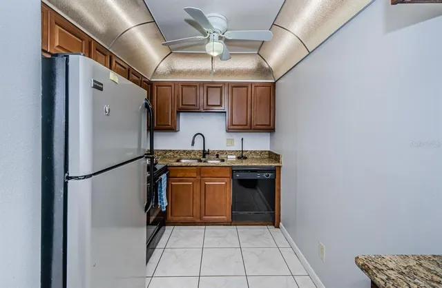 a kitchen with stainless steel appliances granite countertop a refrigerator and a sink