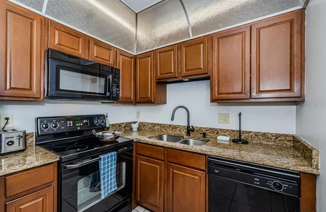 a kitchen with stainless steel appliances granite countertop a sink stove microwave and cabinets