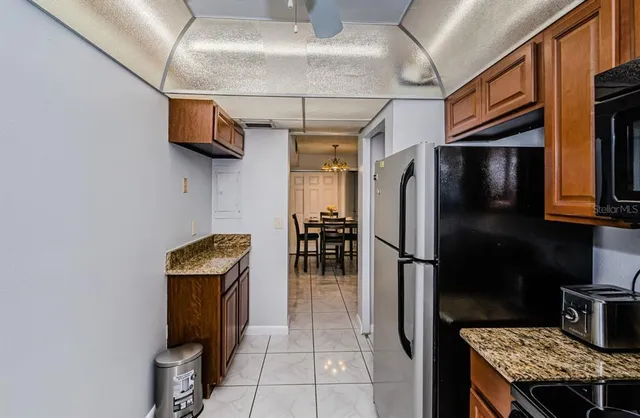 a kitchen with stainless steel appliances granite countertop a refrigerator a stove and a sink