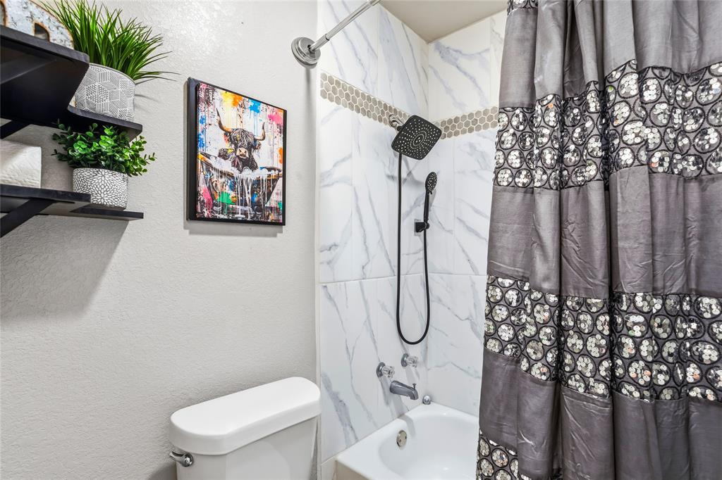 5540 Boca Raton Boulevard, Unit 181 Fort Worth, TX 76112 - Photo 16 of 21 Bathtub shower combination featuring white marble-patterned tile, a mosaic tile accent band, and black shower fixtures