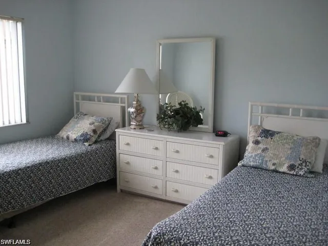 a bedroom with a bed and a potted plant on dresser