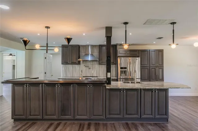 a kitchen with kitchen island granite countertop wooden cabinets and a sink