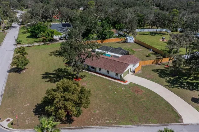 an aerial view of a house with a yard basket ball court and outdoor seating