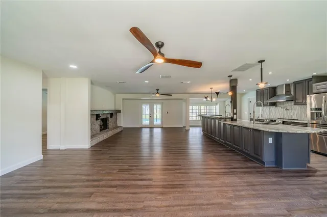 a open kitchen with stainless steel appliances granite countertop a stove top oven a sink and a refrigerator