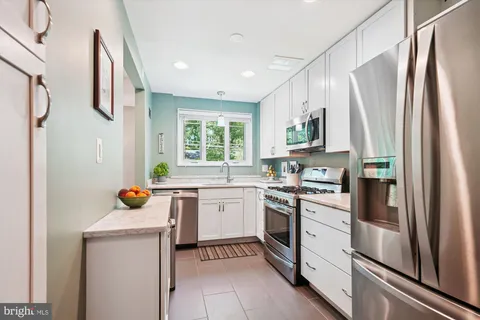 a kitchen with stainless steel appliances a stove a refrigerator and a sink