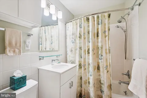 a bathroom with a sink a toilet and shower curtain