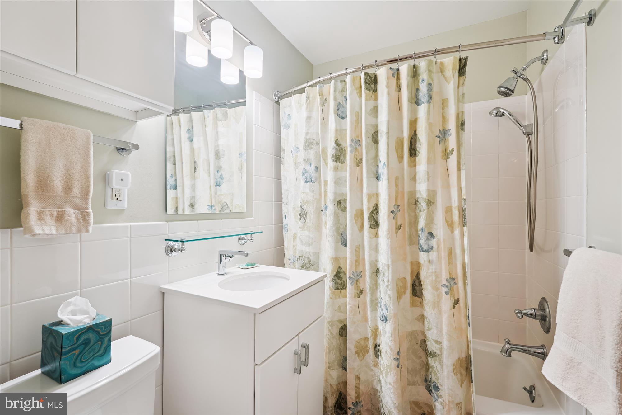 10427 Montrose Avenue, Unit 104 Bethesda, MD 20814 - Photo 20 of 37 a bathroom with a sink a toilet and shower curtain