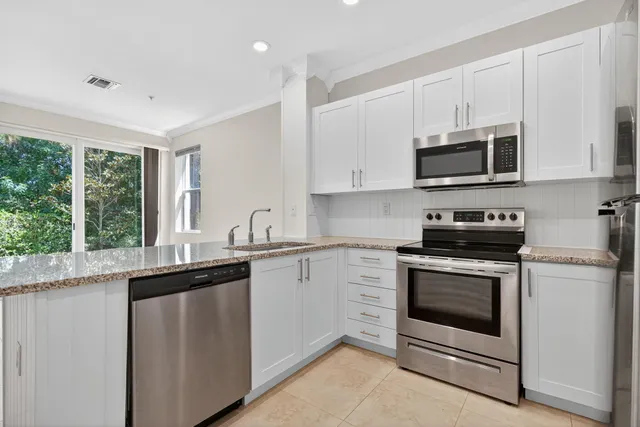 a view of kitchen with refrigerator cabinets and wooden floor