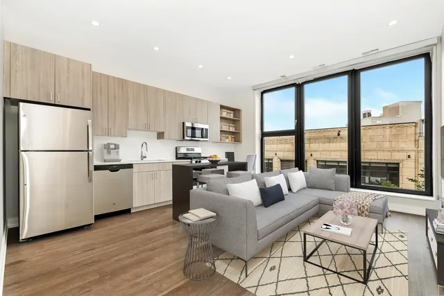 a living room with furniture wooden floor and a refrigerator