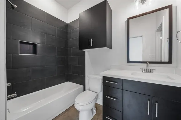 a bathroom with a sink a toilet and shower