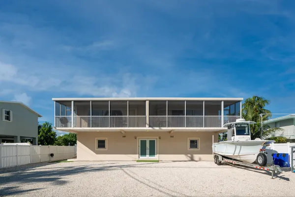 a kitchen with stainless steel appliances a refrigerator a stove a dining table and chairs with wooden floor