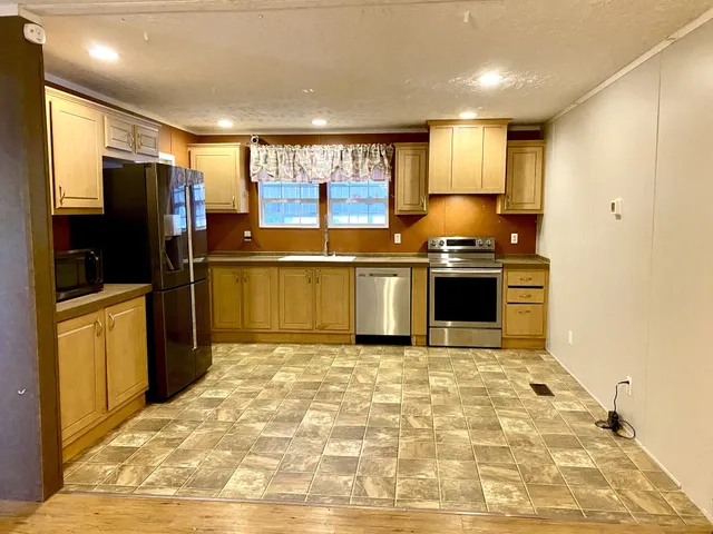 a kitchen with stainless steel appliances granite countertop a stove a sink and a refrigerator