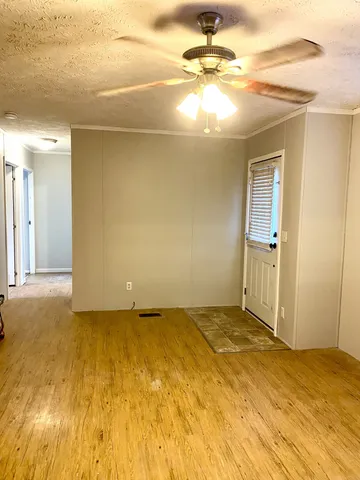 an empty room with a window and ceiling fan