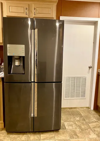 a view of a refrigerator in kitchen and wooden floor