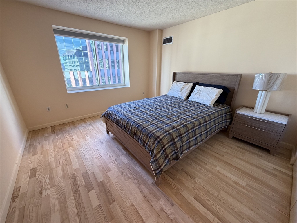 8 Museum Way, Unit 802 Cambridge, MA 02141 - Photo 14 of 39 a bedroom with a bed and wooden floor