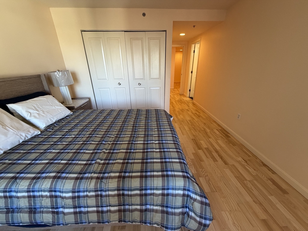 8 Museum Way, Unit 802 Cambridge, MA 02141 - Photo 16 of 39 a bedroom with a bed and a walk in closet