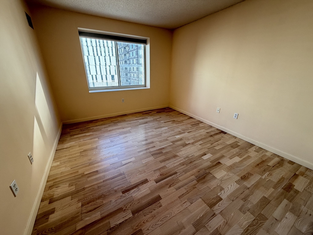8 Museum Way, Unit 802 Cambridge, MA 02141 - Photo 22 of 39 an empty room with wooden floor and windows