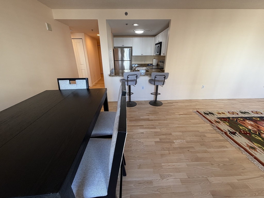 8 Museum Way, Unit 802 Cambridge, MA 02141 - Photo 7 of 39 a living room with stainless steel appliances furniture a rug and a view of kitchen