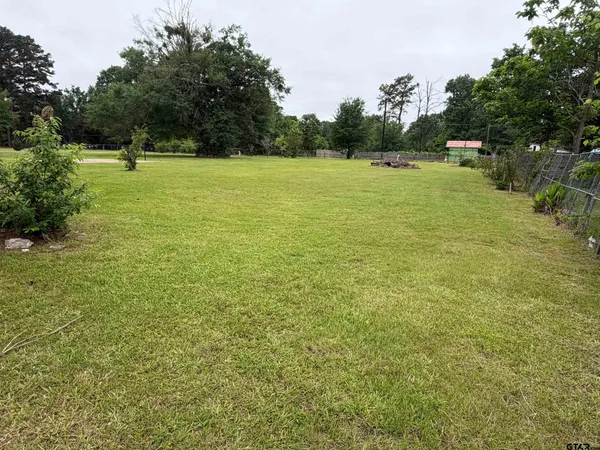 a view of field with trees in the background