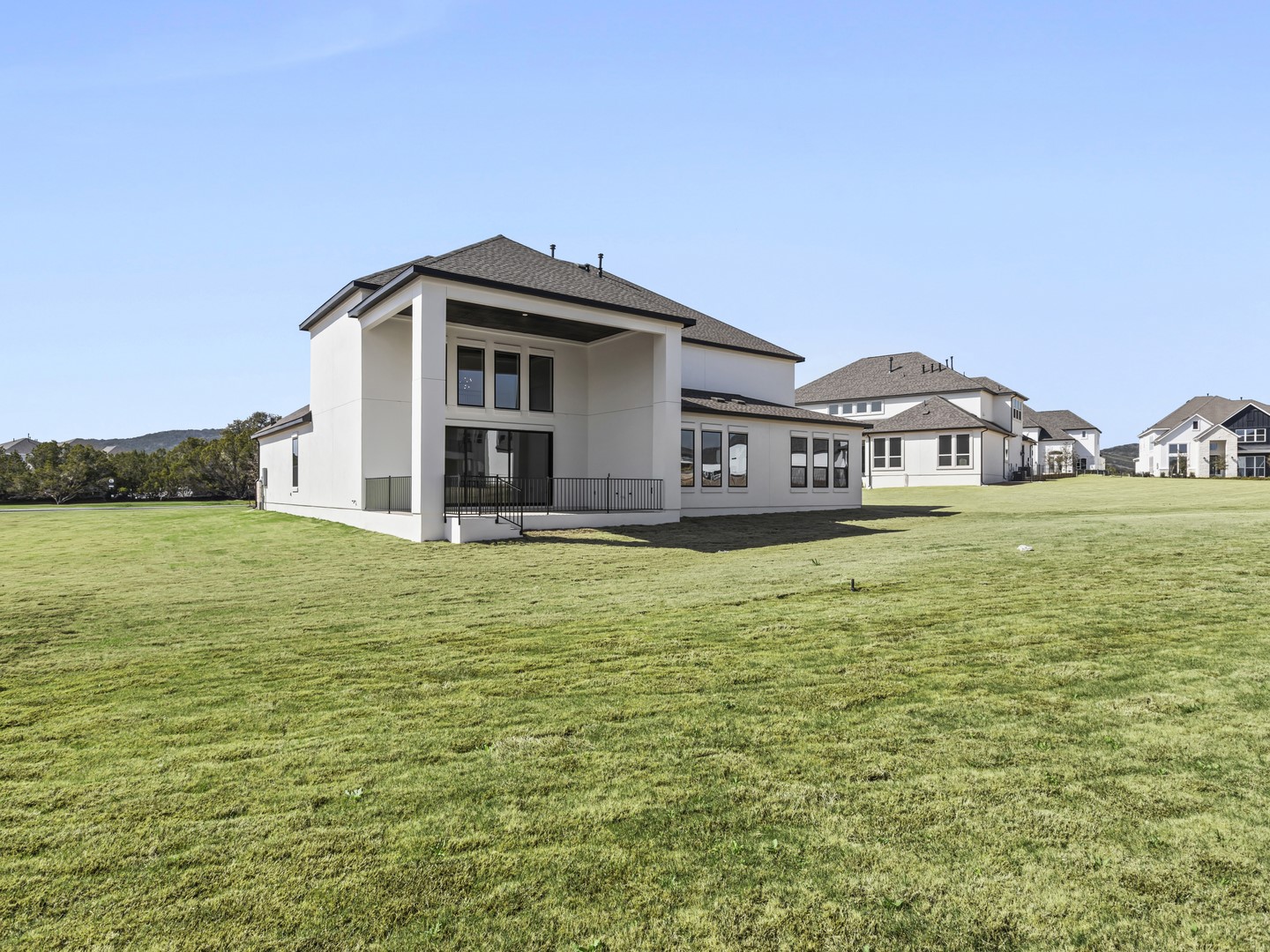 2508 Chiavari Way Leander, TX 78641 - Photo 23 of 24 Modern architecture defines this dwelling, offering a harmonious blend of form and function with a generous green expanse.