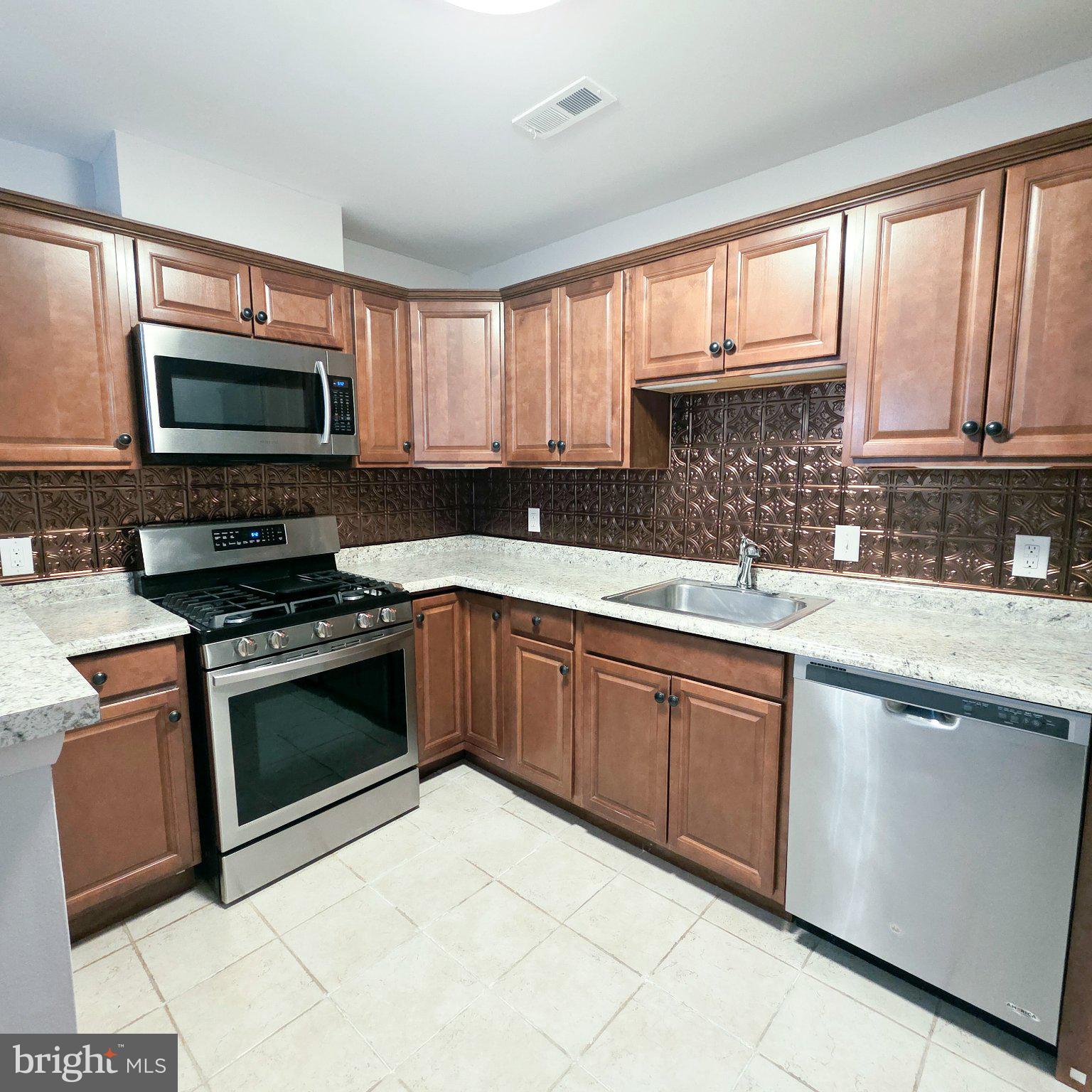 208 Ashley Run Voorhees, NJ 08043 - Photo 12 of 23 a kitchen with granite countertop a stove a sink and a microwave
