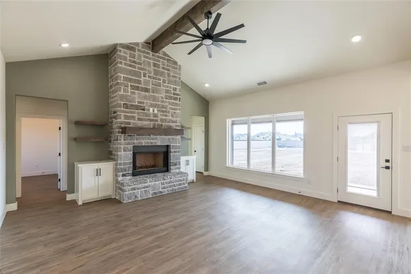 an empty room with windows and a fireplace