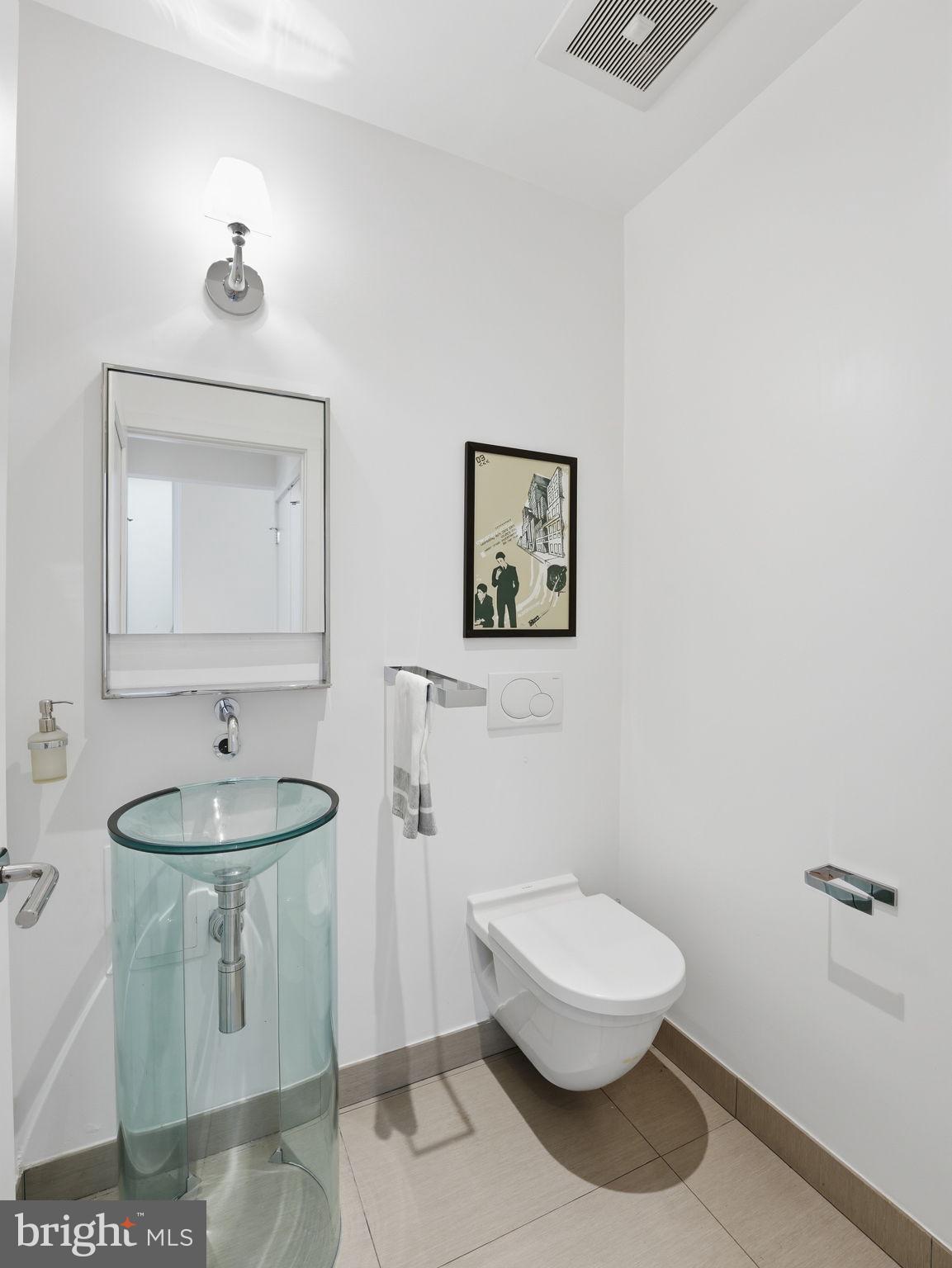 1845 Calvert Street Northwest Washington, DC 20009 - Photo 39 of 48 a bathroom with a toilet a sink and mirror