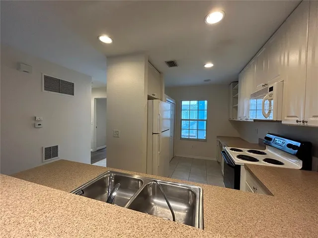 a kitchen with stainless steel appliances granite countertop a sink a stove and a refrigerator