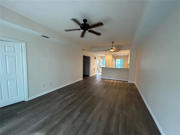 a view of a hallway with wooden floor and a livingroom