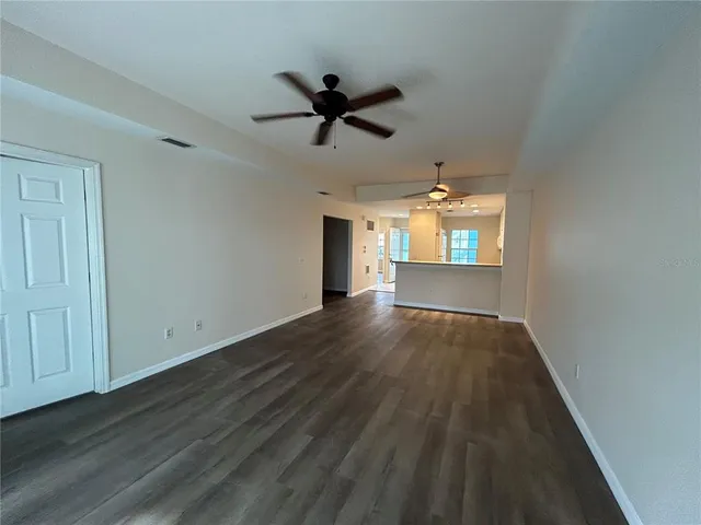 a view of a hallway with wooden floor and a livingroom