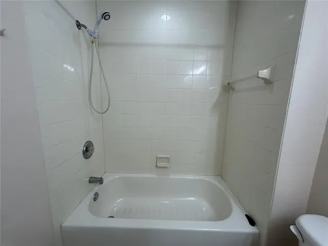 a white bath tub sitting next to a white sink and a shower