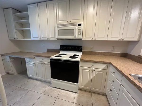 a kitchen with a refrigerator a stove top oven and a sink