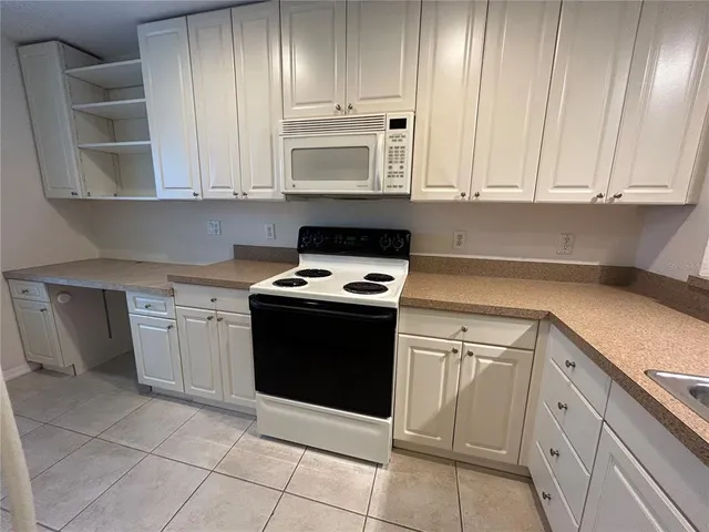a kitchen with a refrigerator a stove top oven and a sink