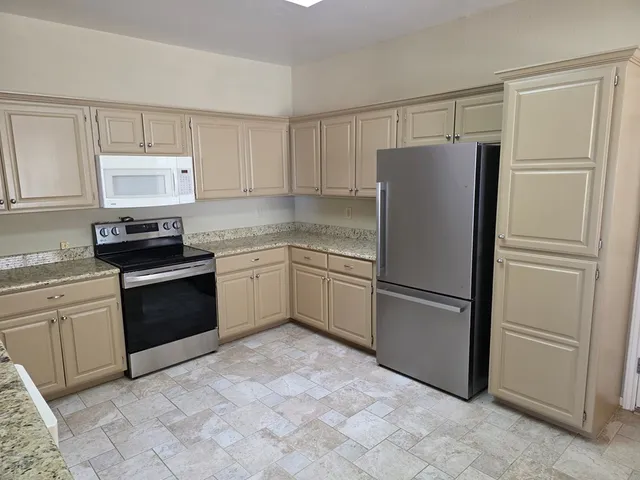 a kitchen with a refrigerator sink and cabinets