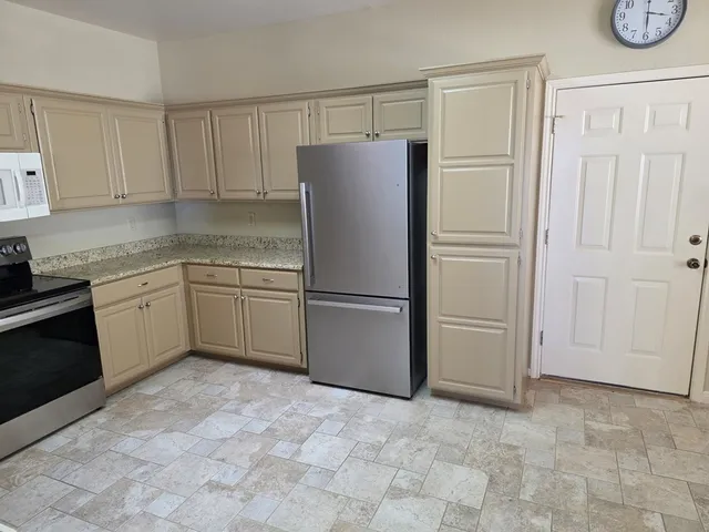 a kitchen with a refrigerator sink and cabinets