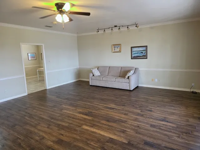 a living room with hard wood floors and a ceiling fan