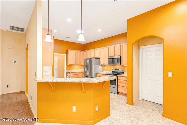 a kitchen with stainless steel appliances granite countertop a sink a stove and a refrigerator