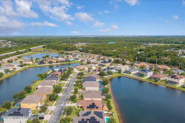 an aerial view of residential houses with outdoor space and lake view