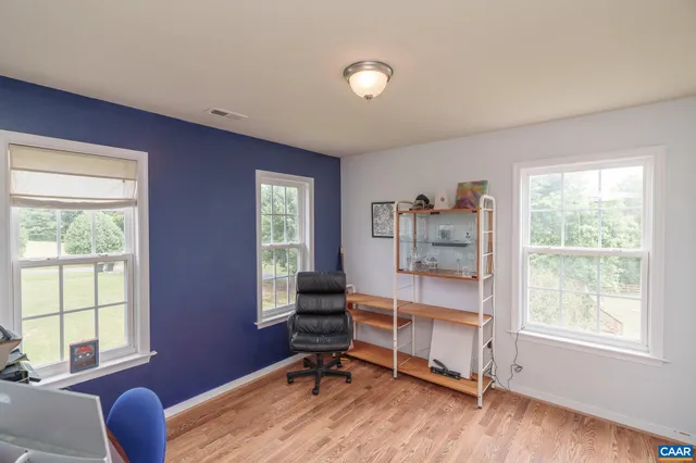 a workspace with wooden floor and a window