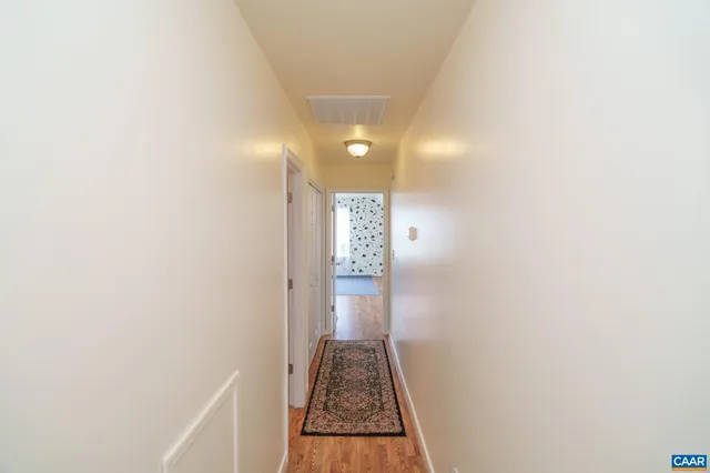 a view of a hallway to a house with stairs