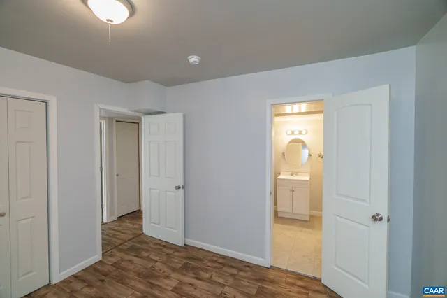 a view of a house with a big yard potted plants and a large tree