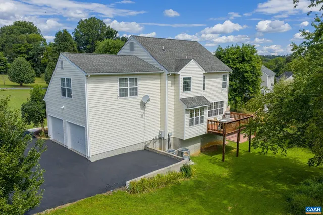 a aerial view of a house with a yard potted plants and a bench