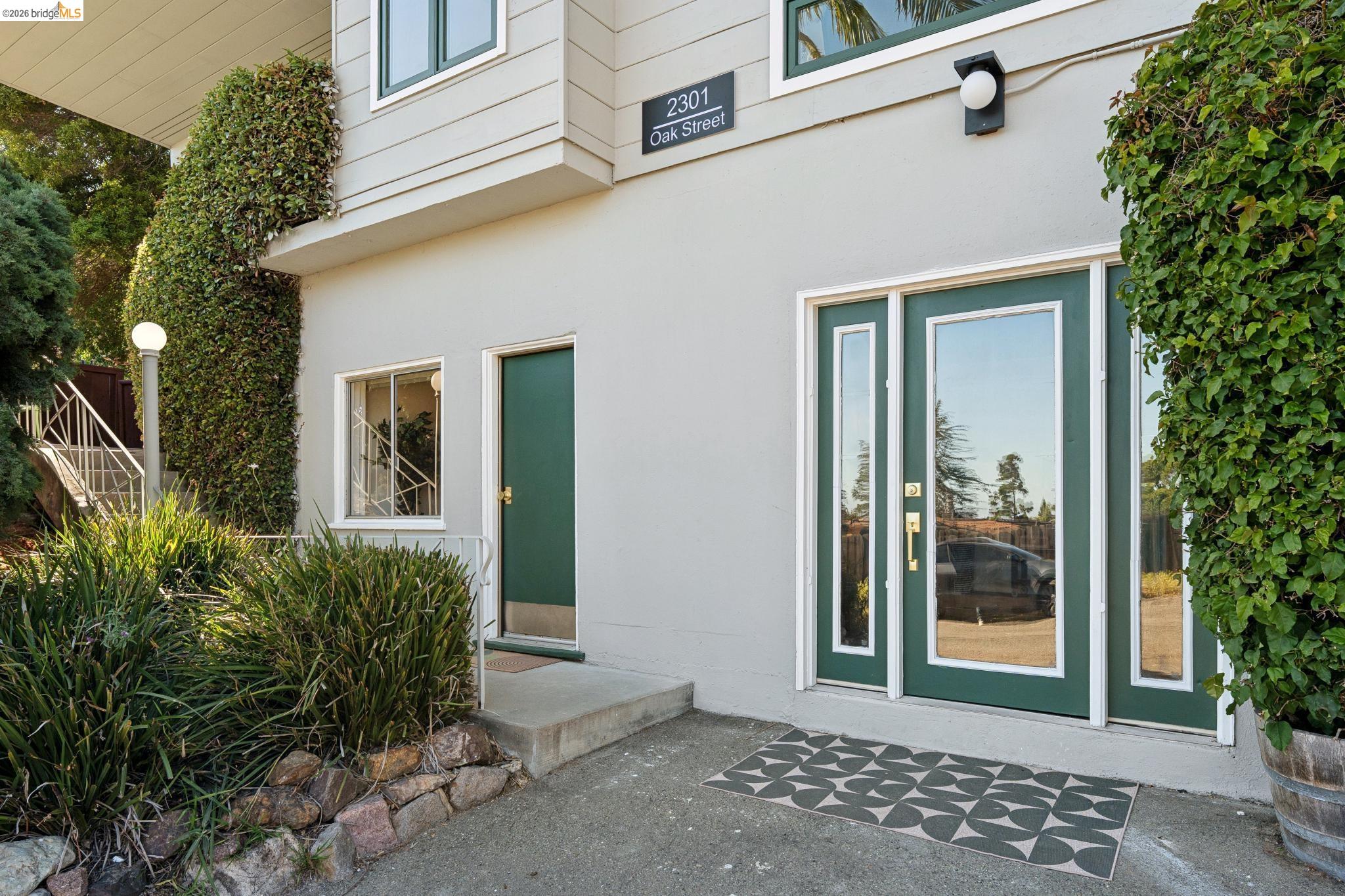2301 Oak Street Berkeley, CA 94708 - Photo 47 of 61 Entryway featuring a green paneled door with sidelights, a coordinated green door, and a ground-floor window