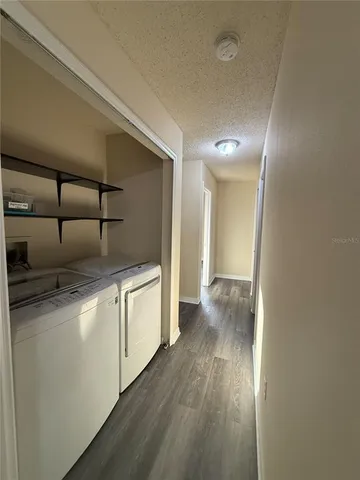 a kitchen with white cabinets and wooden floor