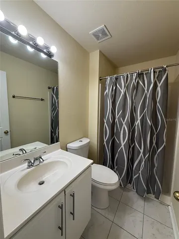a bathroom with a sink a toilet a mirror and shower