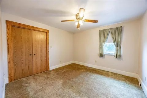 an empty room with windows and ceiling fan