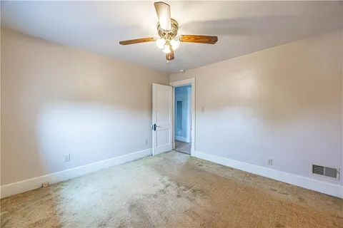 a view of an empty room with a chandelier fan