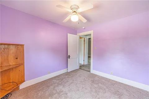 a view of a livingroom with a chandelier fan and a window