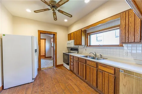 a kitchen with stainless steel appliances a sink cabinets and wooden floor